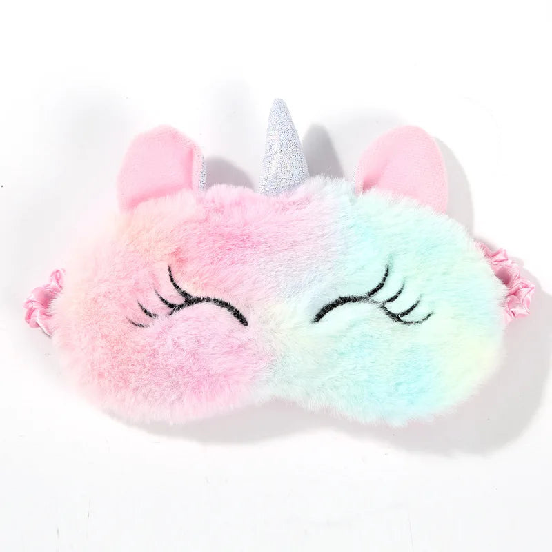 Plush unicorn eye mask with rainbow gradient on a white background