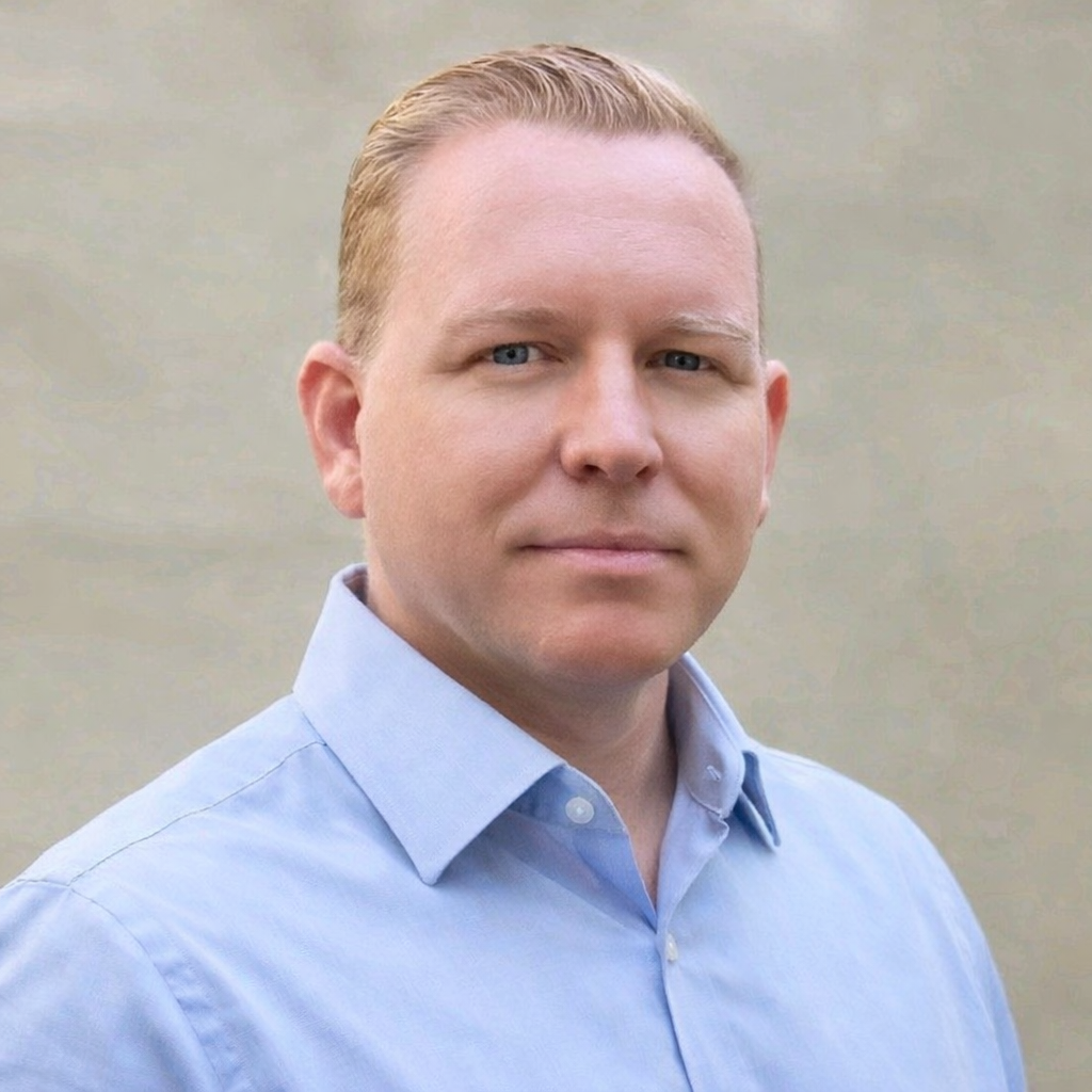 Man wearing a light blue shirt against a neutral background