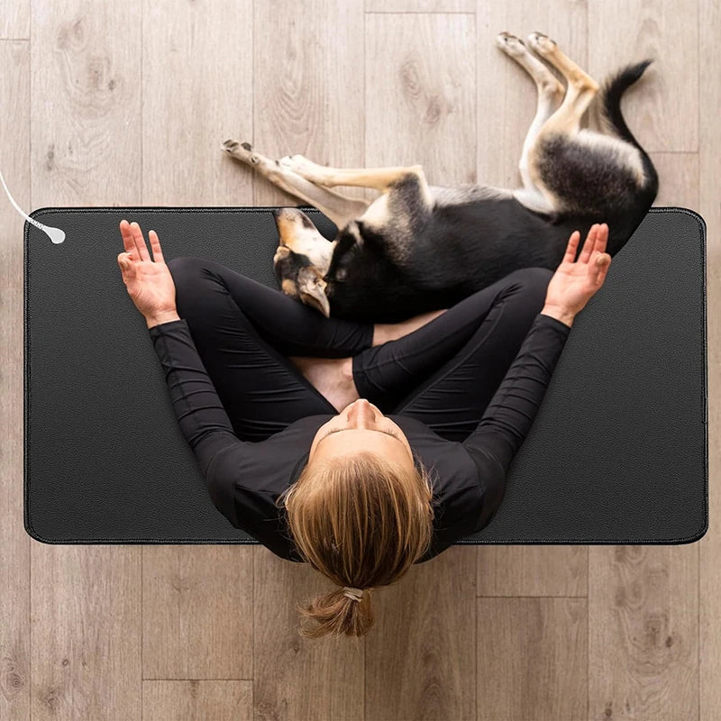 Person and dog lying on a yoga mat on a wooden floor