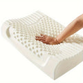 White foam pillow with hand pressing into it on a white background