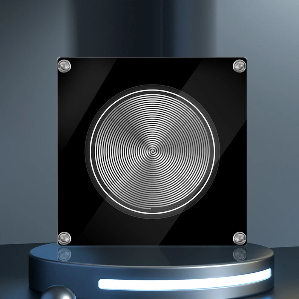 Black square object with circular pattern on a reflective surface