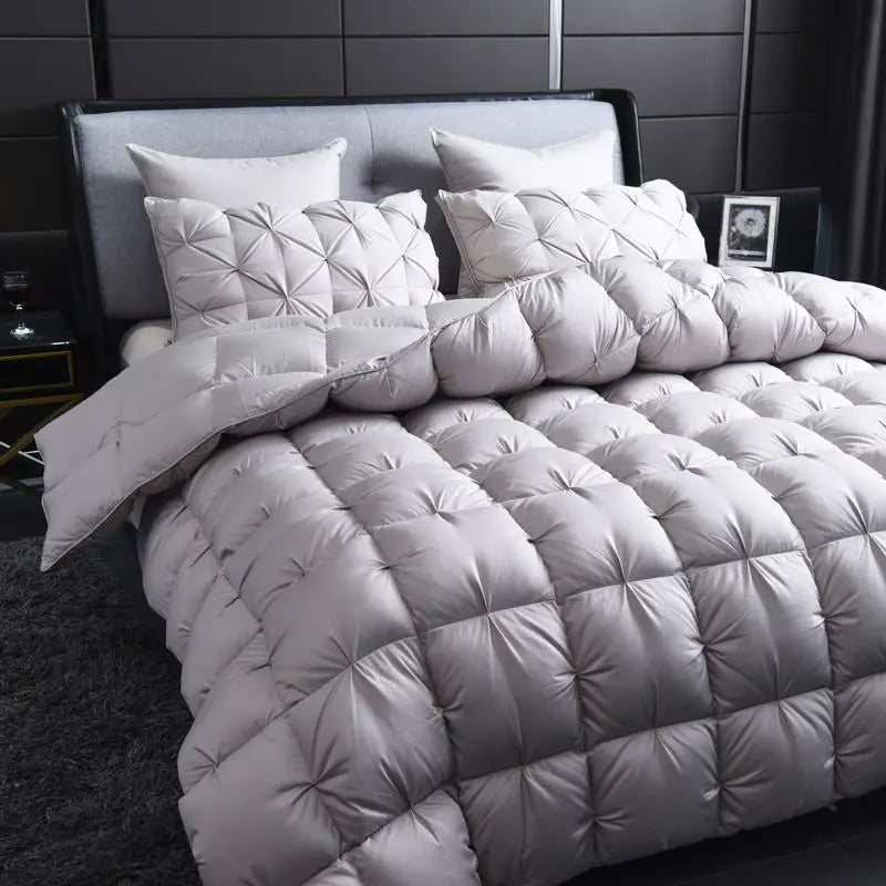Gray quilted comforter set on a bed in a bedroom setting.