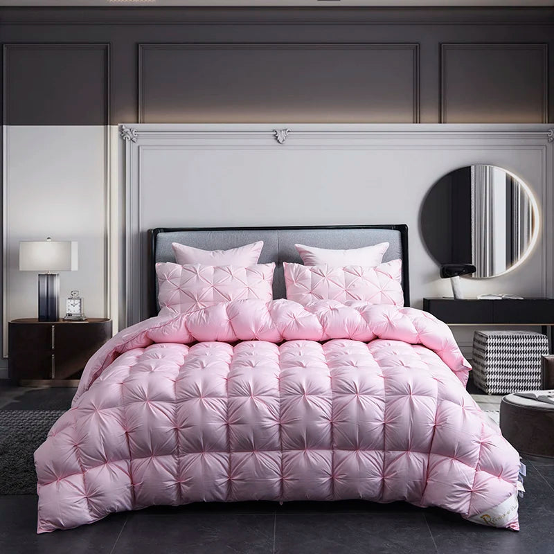 Pink quilted comforter set on a bed in a bedroom setting with a lamp and mirror.