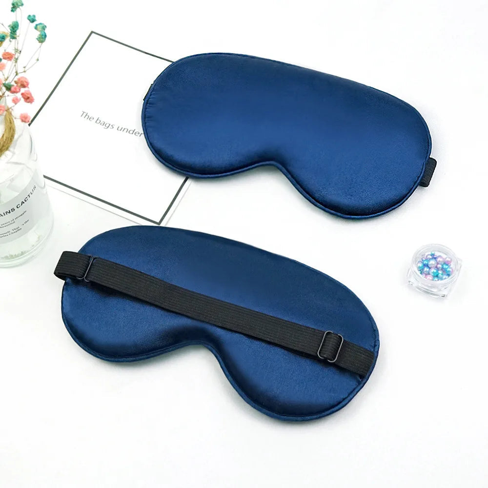 Two blue sleep masks on a white surface 