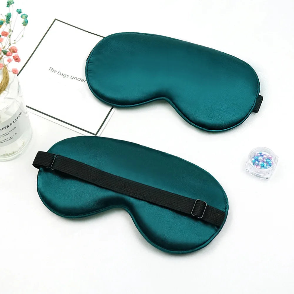 Two teal sleep masks on a white surface