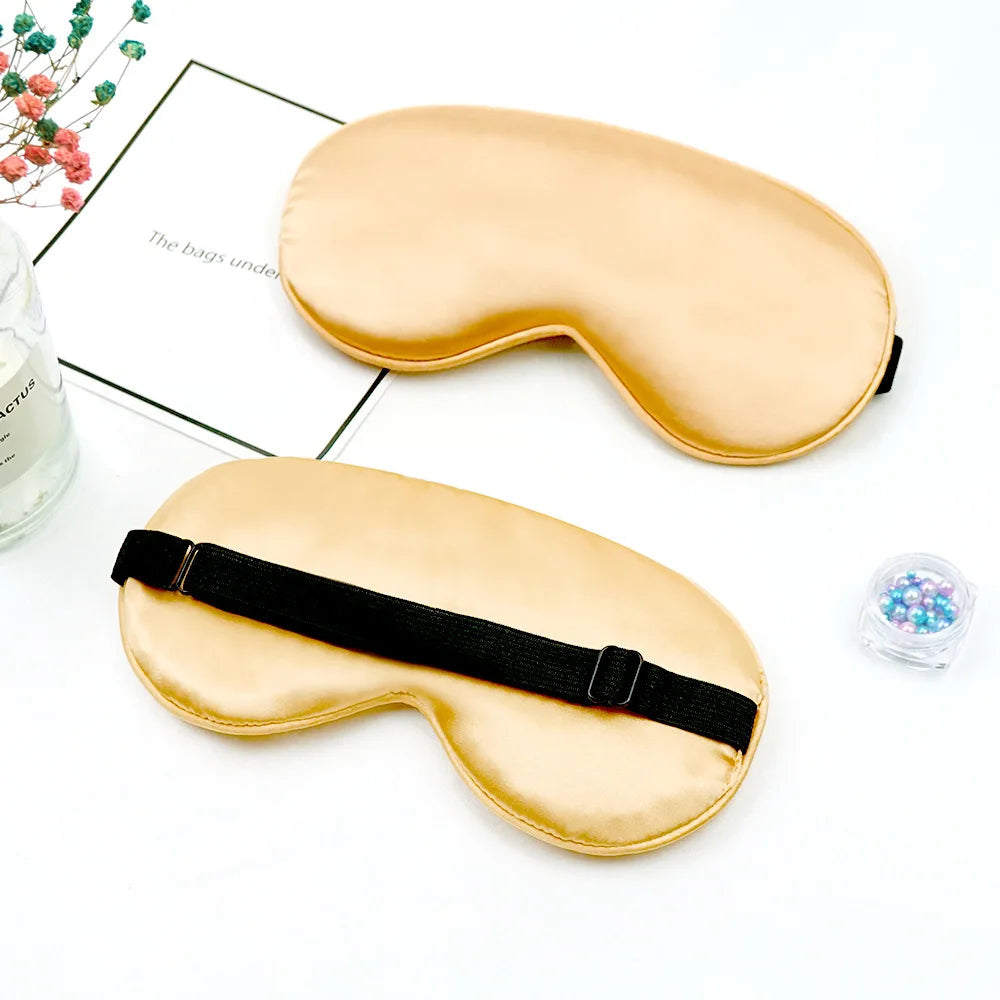 Two gold sleep masks on a white surface