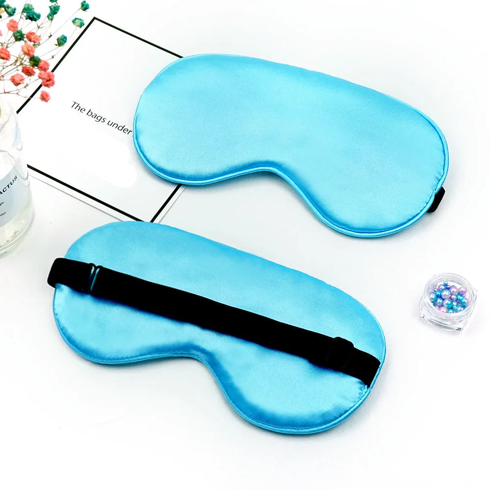 Two blue sleep masks on a white surface