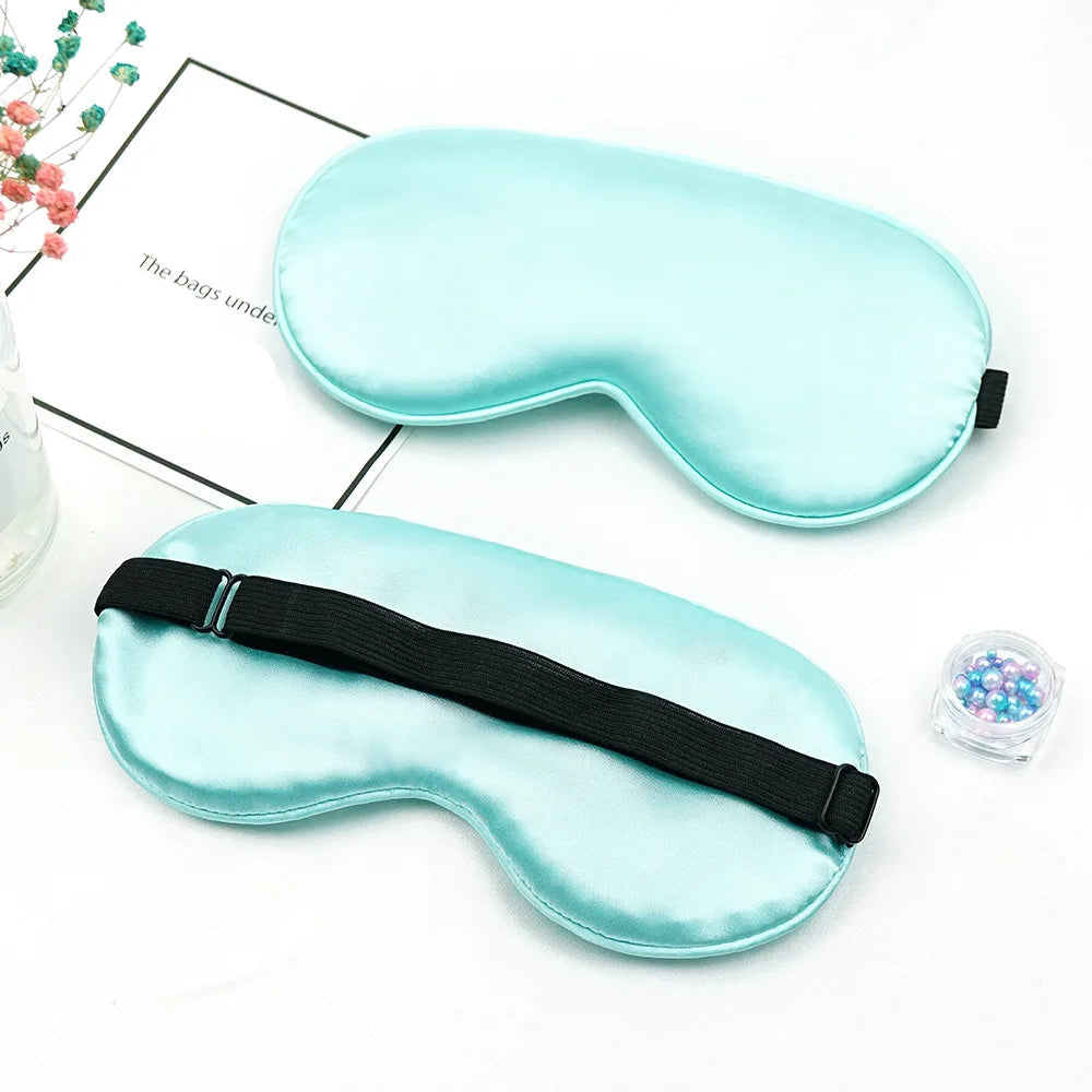 Two light green sleep masks with black straps on a white background.
