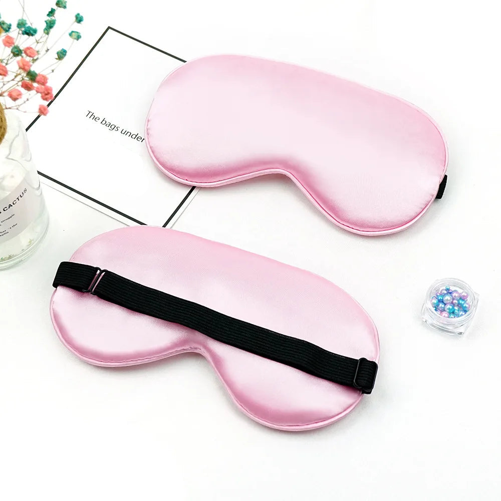 Two pink sleep masks on a white surface 