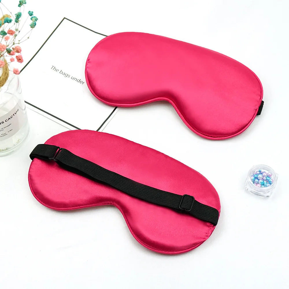 Two red sleep masks on a white surface 