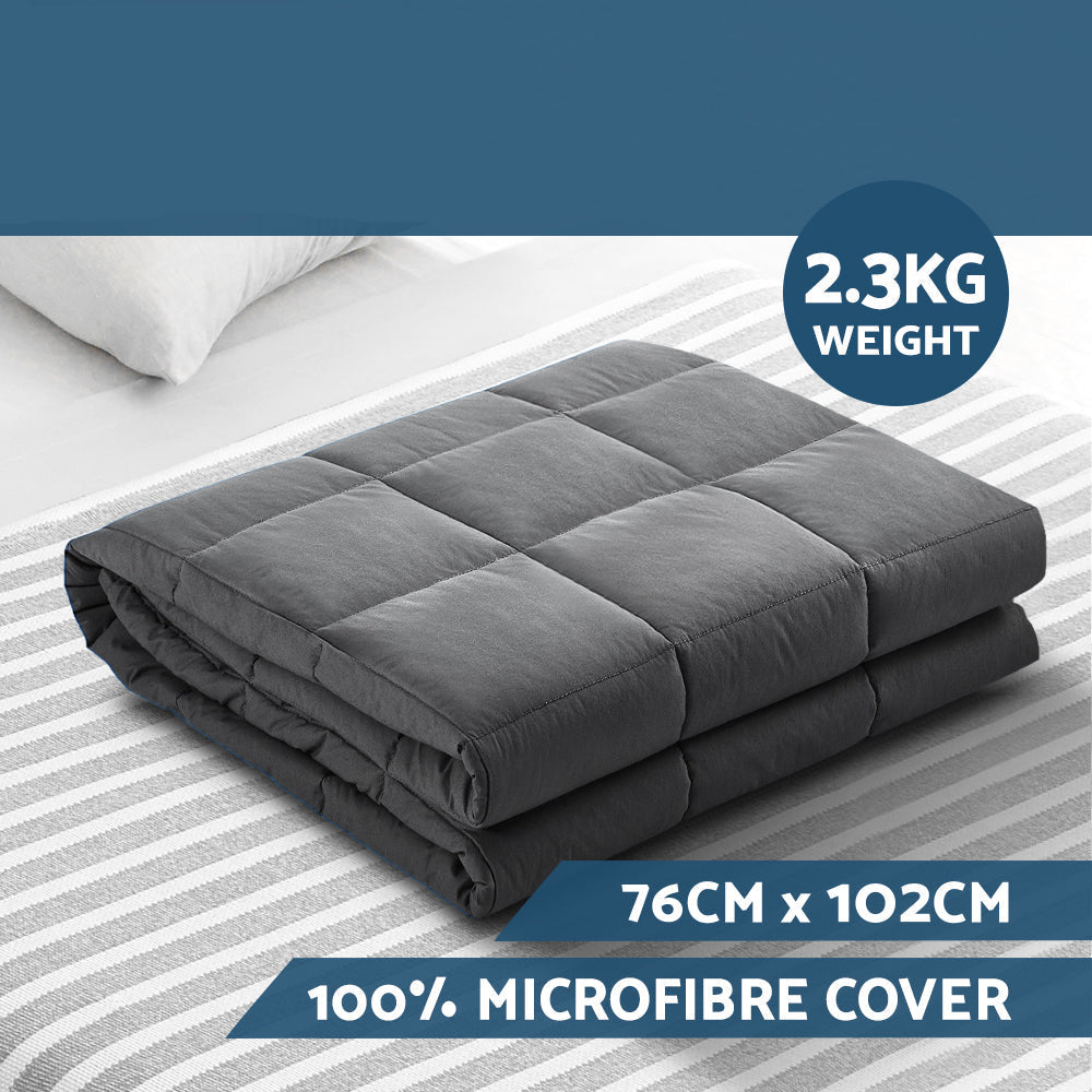 Gray weighted blanket with Giselle Bedding branding on a bed with striped bedding.